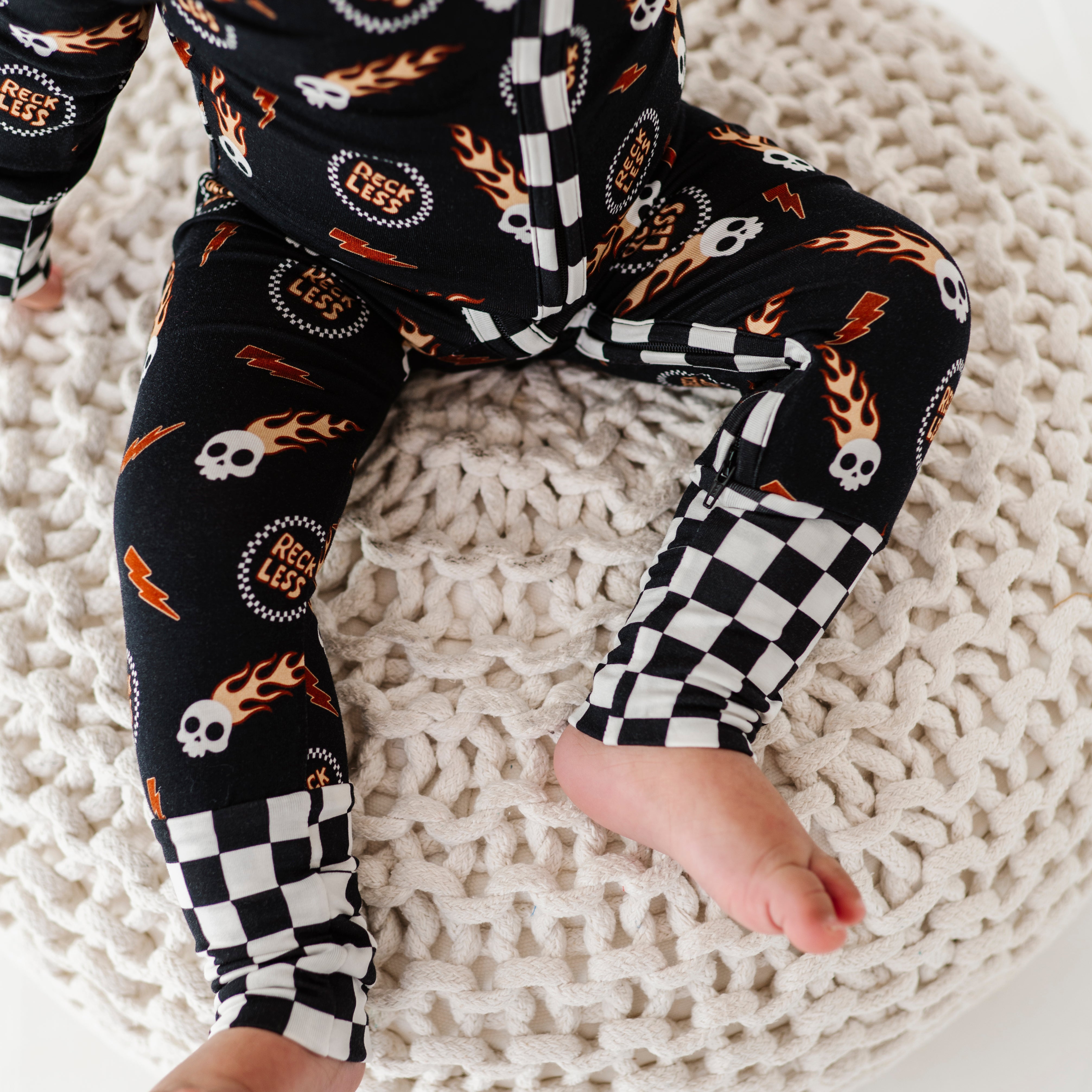 details on Reckless-themed bamboo baby outfit with zipper and fold-over footies