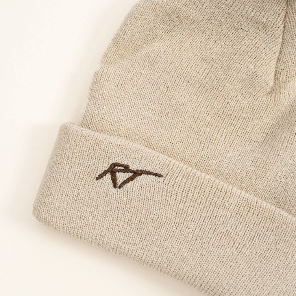 Beige beanie with a logo on a light beige background