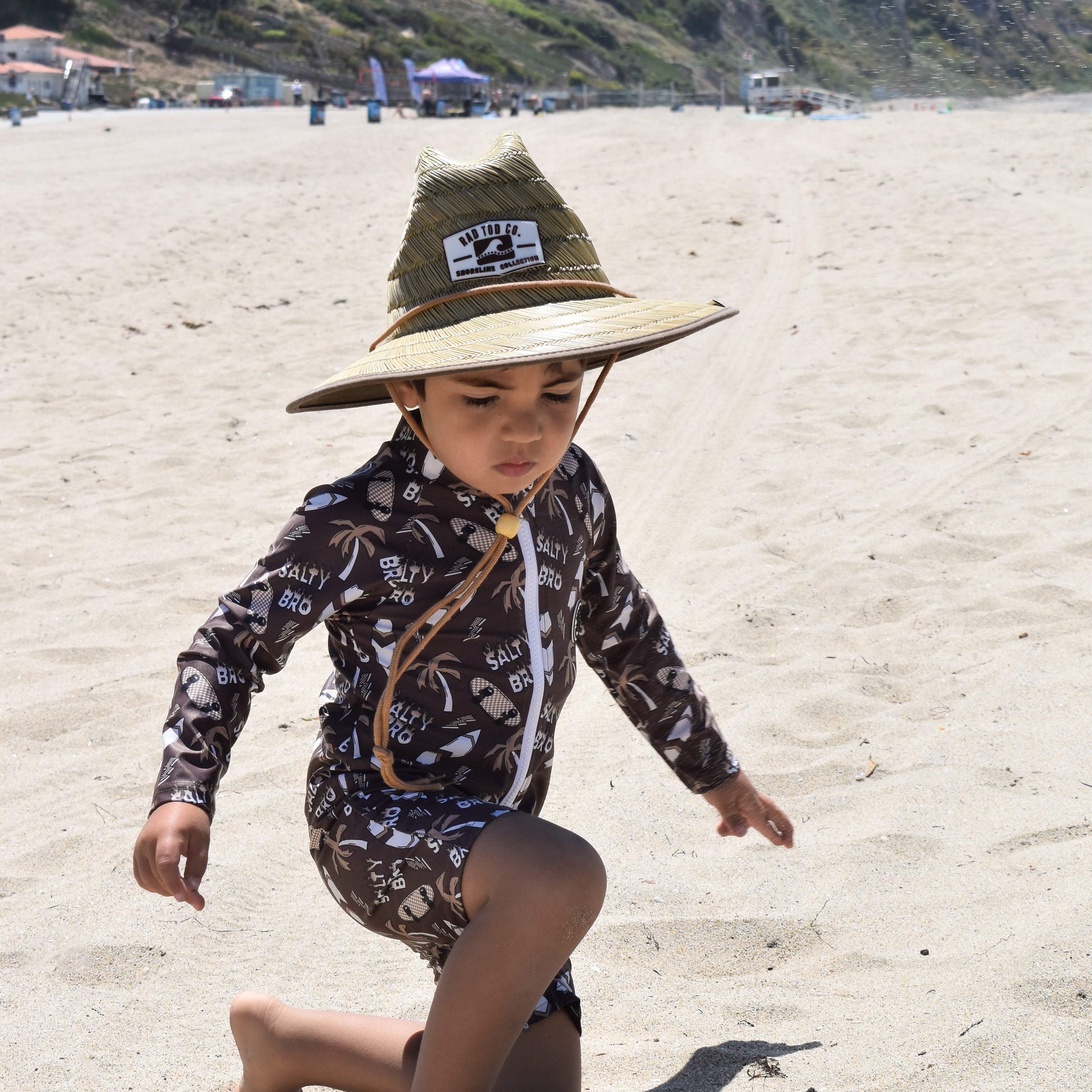 Child wearing rashguard onesie at the beach