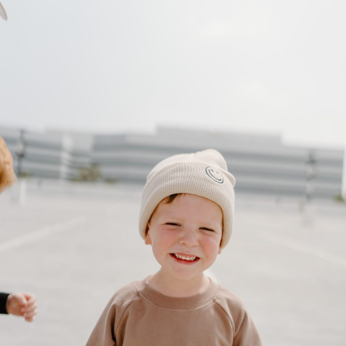 child wearing the bee happy sandstone beanie by rad toddler