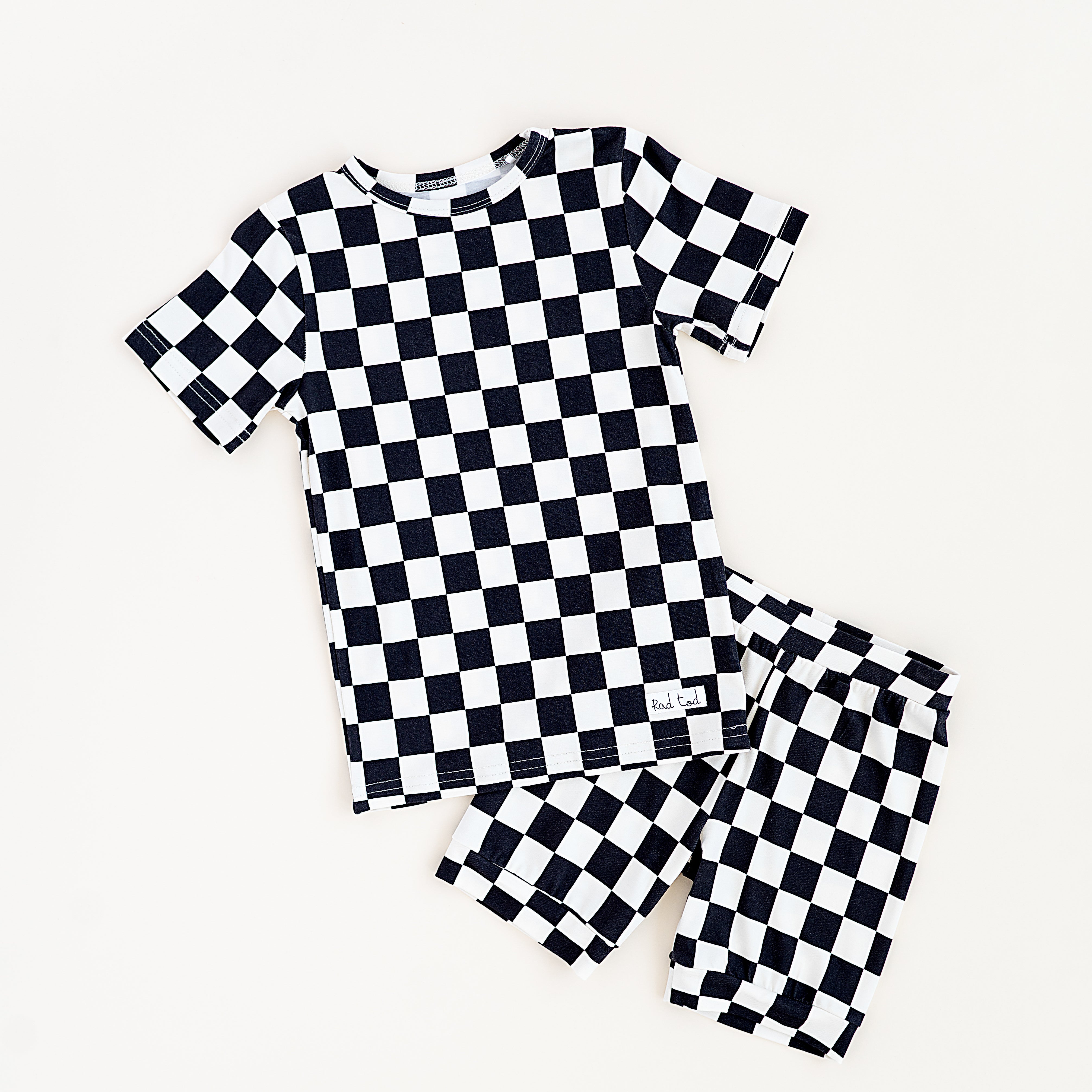 Black and white checkered bamboo short sleeve pajama set for toddlers, featuring a soft, breathable fabric and stretchy waistband by Rad Toddler.
