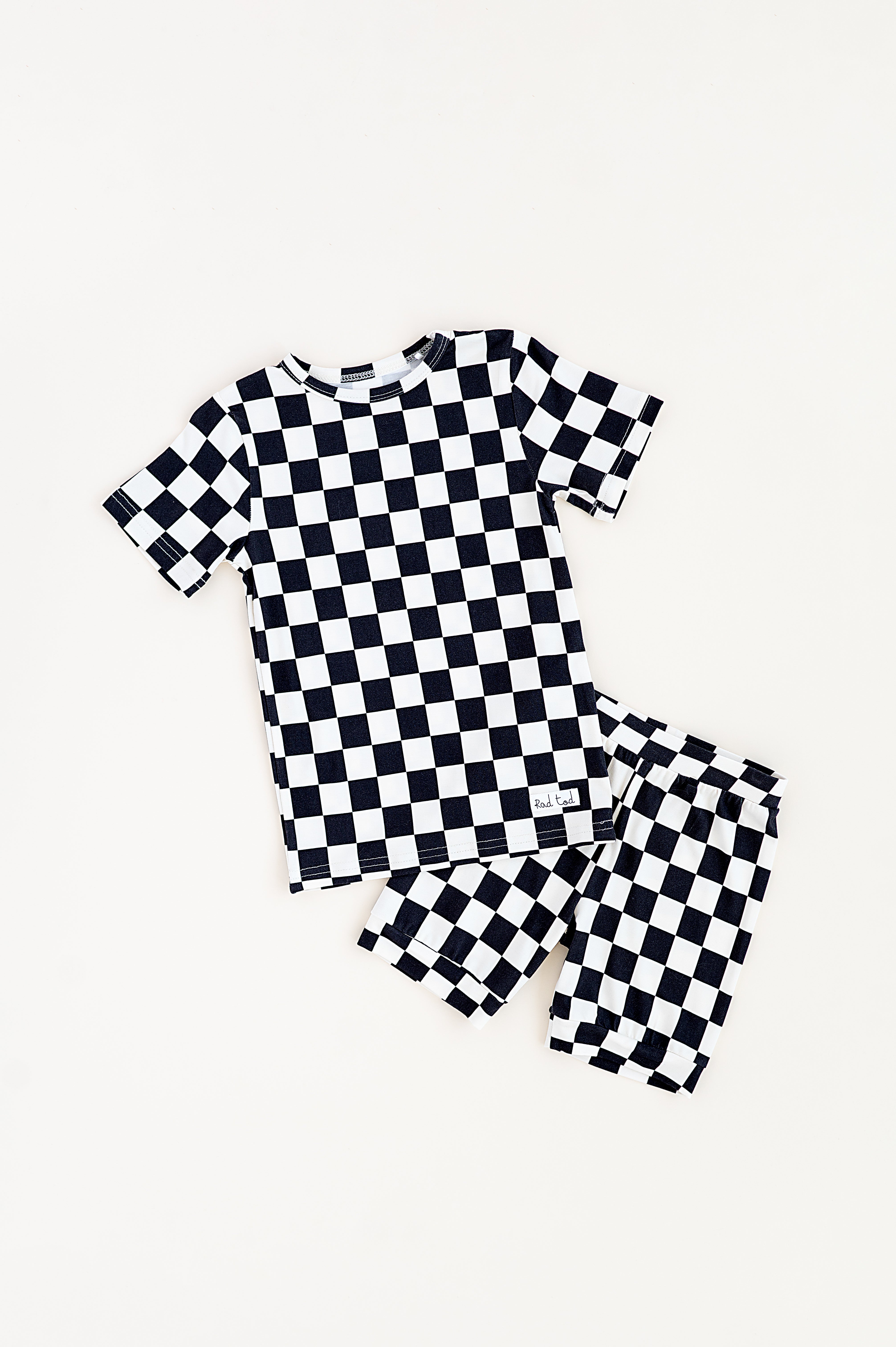 Black and white checkered bamboo short sleeve pajama set for toddlers, featuring a soft, breathable fabric and stretchy waistband by Rad Toddler.
