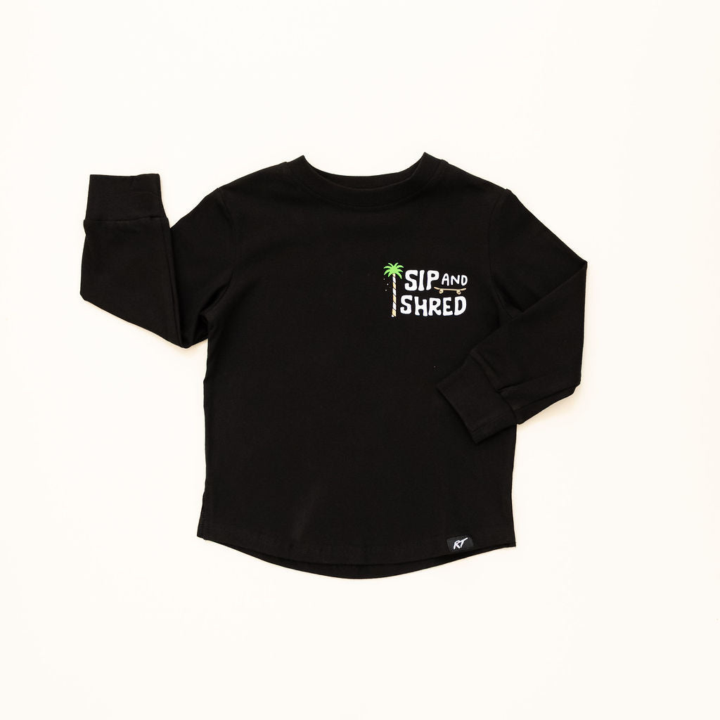 Black long-sleeve shirt with 'Sip and Shred' text on a white background