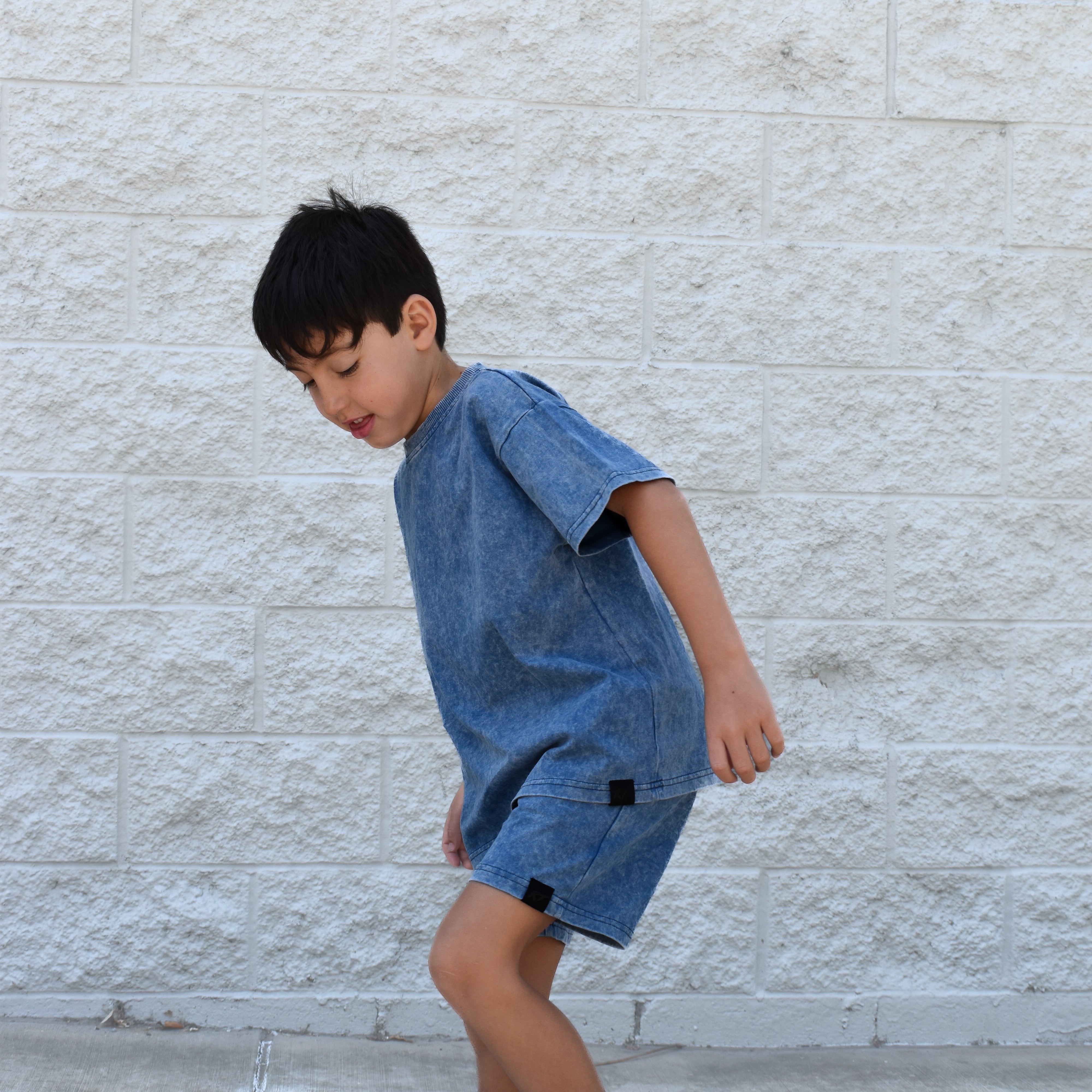 Kids vintage blue stone wash shorts with soft faded fabric, elastic waistband, and relaxed everyday fit paired with matching stone wash tee.