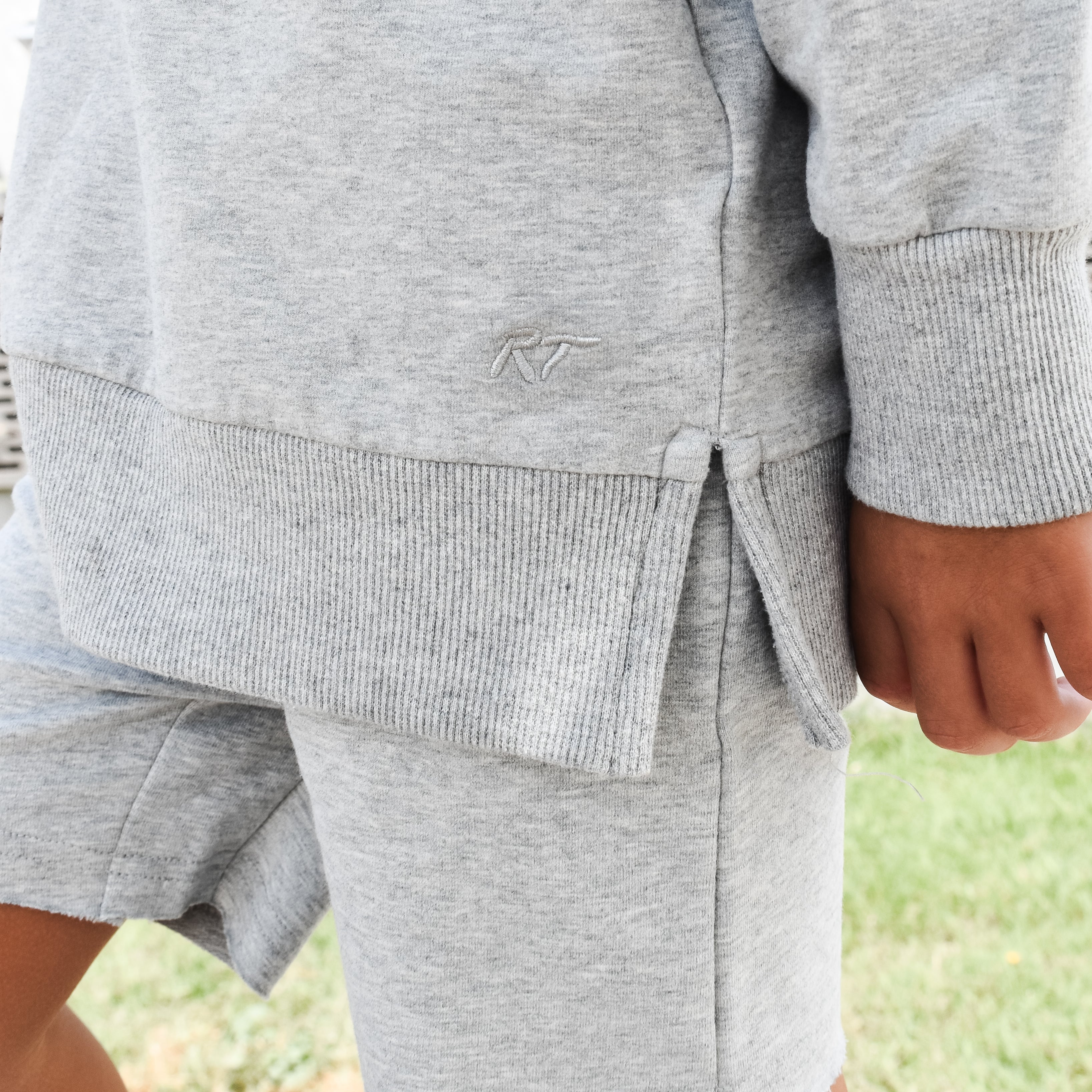 Young boy wearing gray Core Collection toddler crewneck with oversized fit, standing outdoors these are the details