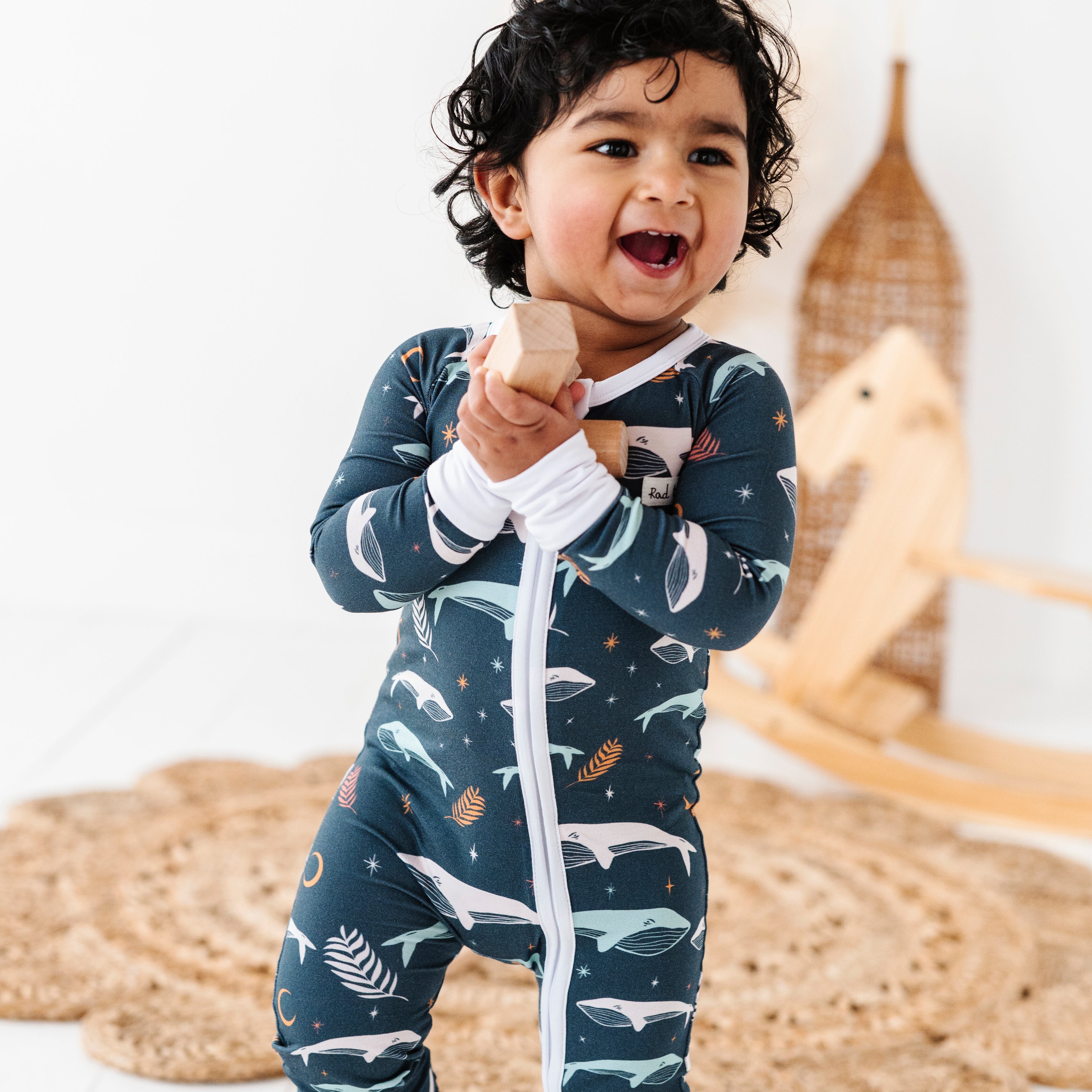 Boy wearing Luna Whale Bamboo Onesie featuring soft, breathable fabric, hypoallergenic properties, and a cute whale design for ultimate comfort and style.