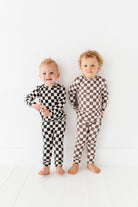 2 friends enjoying their Black checkered 2-piece pajamas for toddlers and kids, featuring a comfy fit and elastic waistband by Rad Toddler.