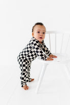 Toddler wearing black and white checkered bamboo onesie