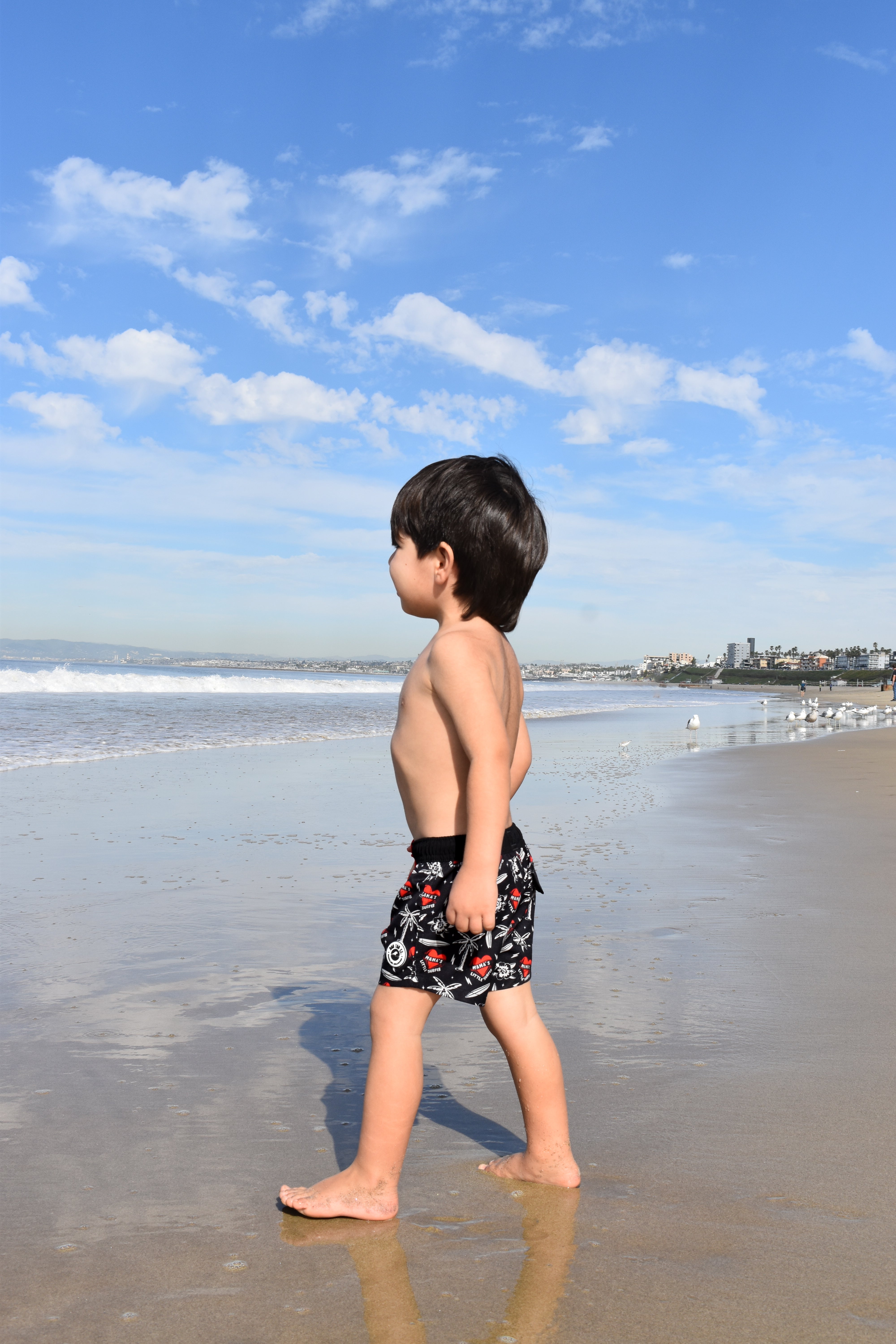 Little surfer wearing Mama’s Little Surfer Swimmie, mom-approved summer outfit by Rad Toddler