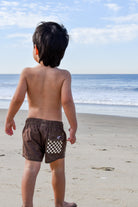 Child wearing Choco Swimmie brown checker swimsuit at the beach