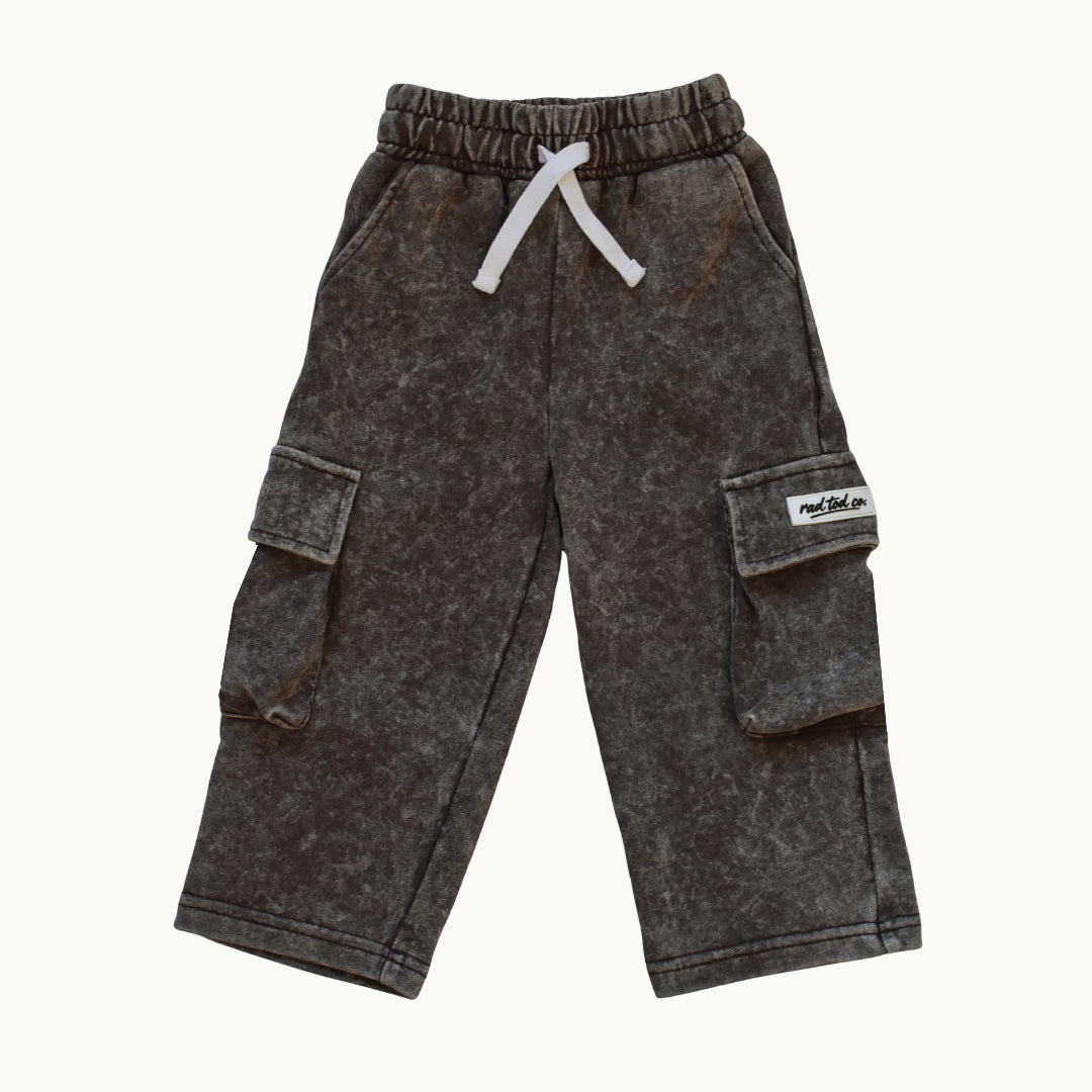 A pair of children's espresso acid-wash cargo pants with a white drawstring and a small white brand patch on the side pocket, shown against a plain off-white background.
