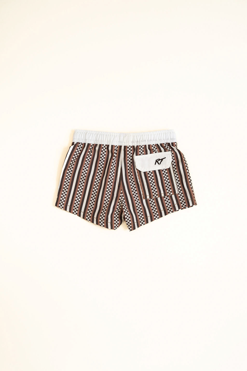 Brown and white patterned shorts with a logo on a beige background