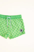 Green checkered shorts with a Rad Toddler logo on a white background detail shot