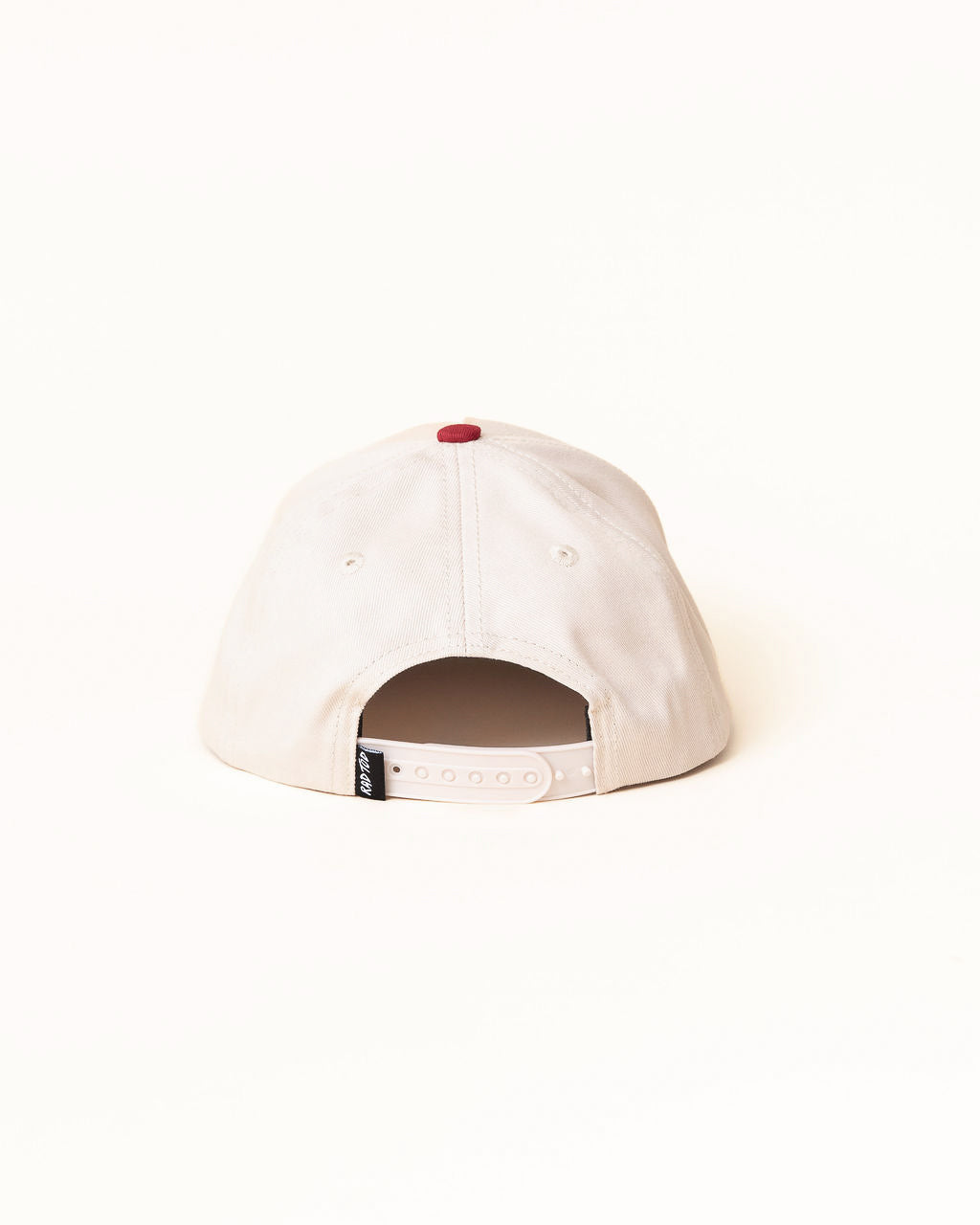 White cap with a red button on a white background