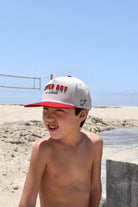 Young boy wearing a cap with Lover Boy hat on a beach
