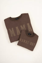Two brown sweatshirts, one with 'MAMA' and the other with 'MAMA'S BOY', on a white background.