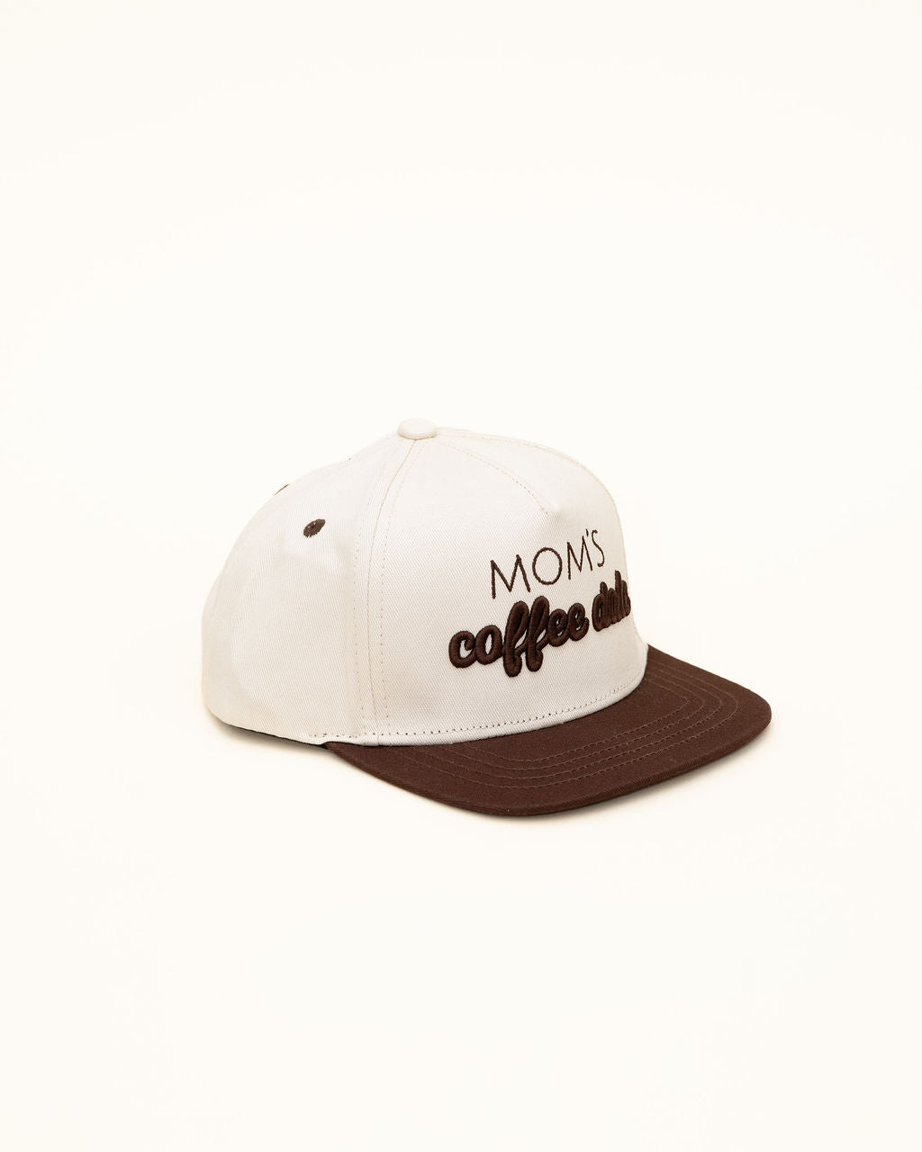White cap with brown brim featuring 'MOMS coffee addict' text on a white background