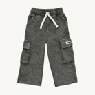A pair of washed dark moss pants for kids, featuring an elastic waistband with a white drawstring and side cargo pockets, shown against a plain off-white background.