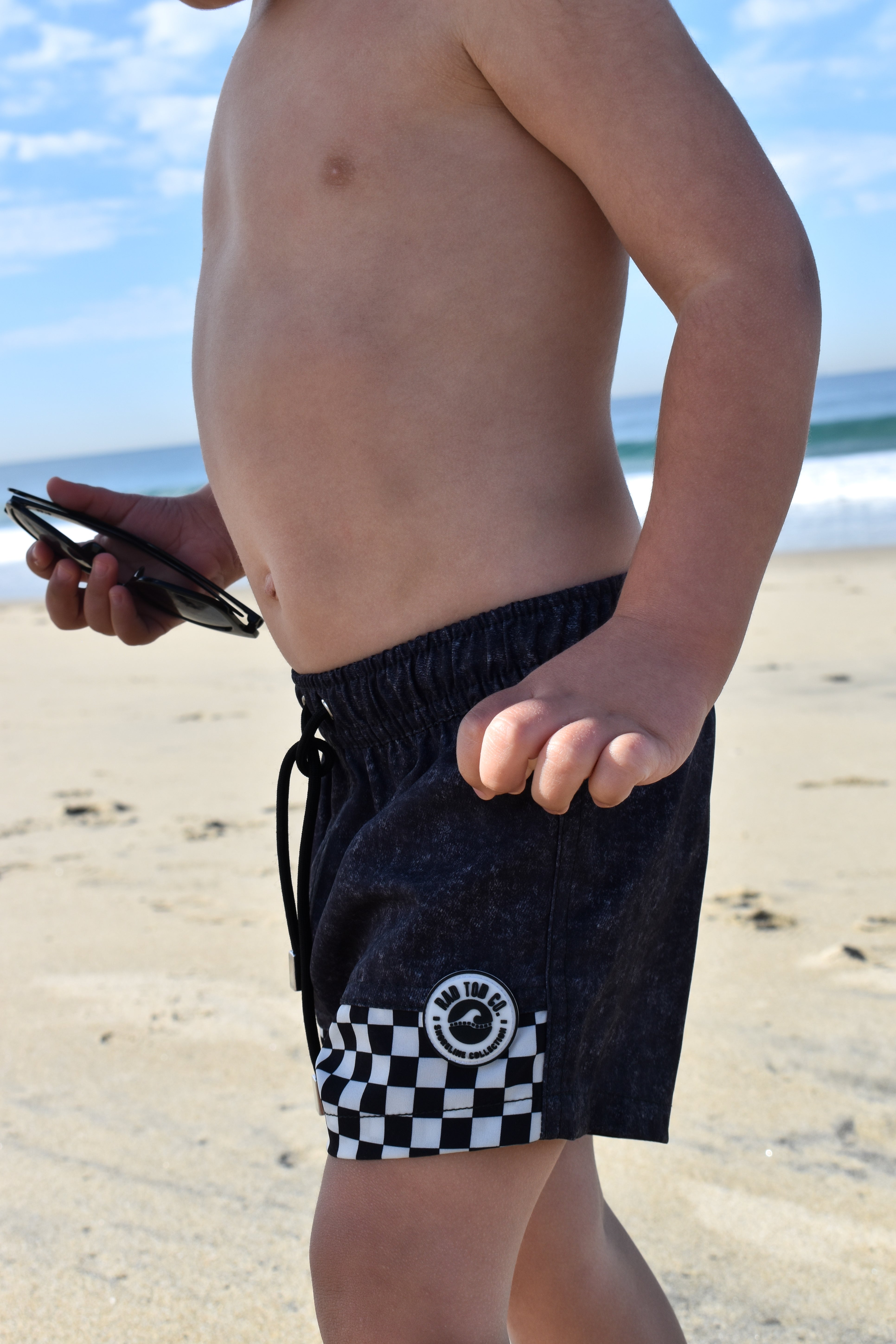 Child wearing Onyx Swimmie black checker swimsuit at the beach