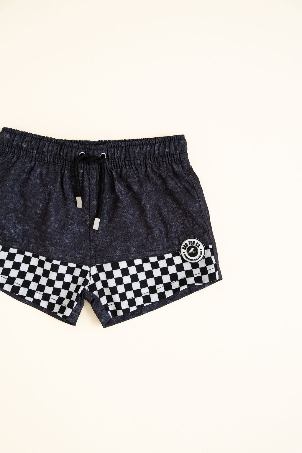 Black shorts with a checkered pattern on a white background by Rad Toddler