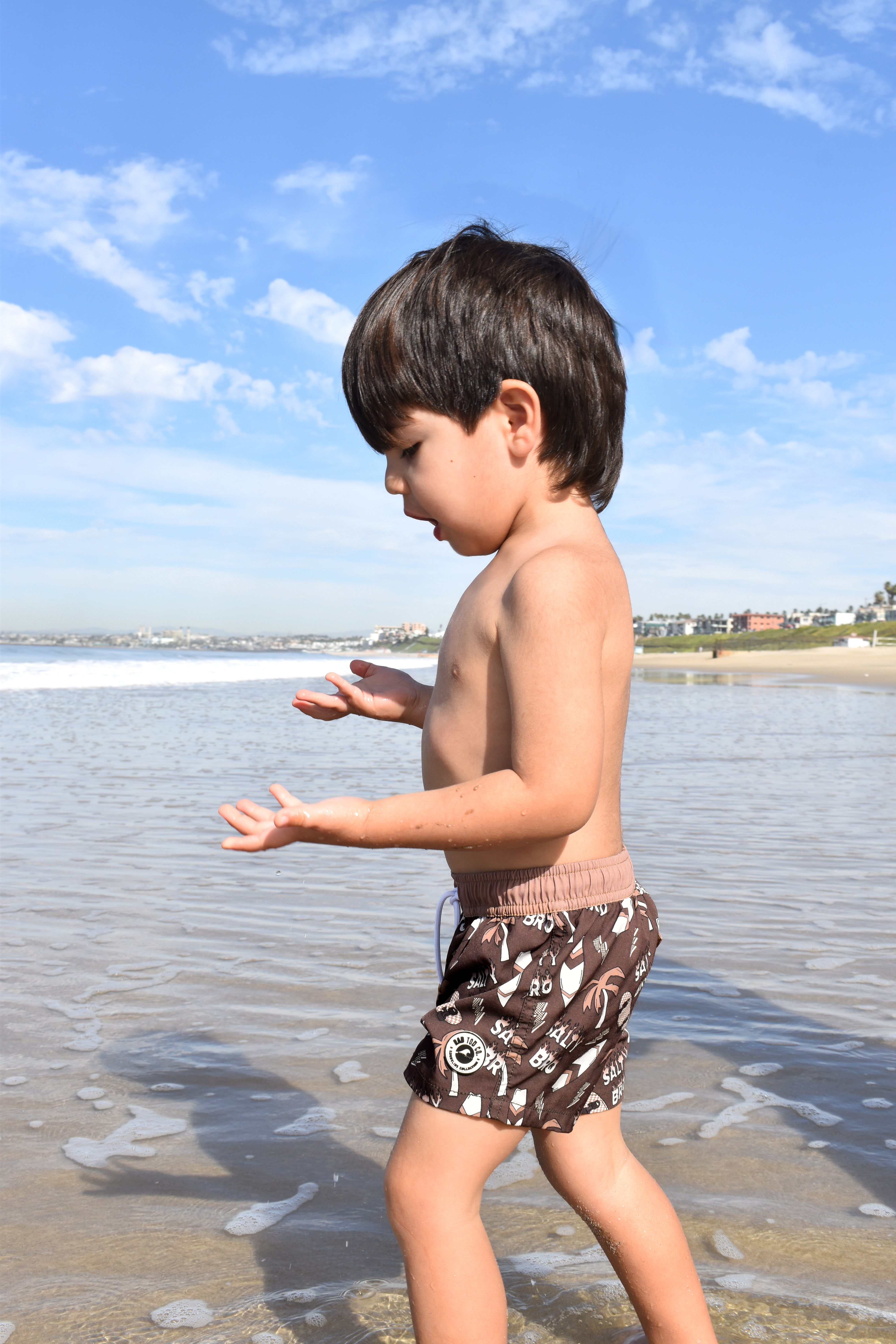Toddler wearing Salty Bro Shorts in brown with surf-inspired graphics