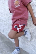 Red and white check shorts with relaxed fit, lightweight polyester fabric, and everyday streetwear style