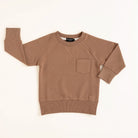 Flat lay of almond toddler crewneck from the Core Collection with oversized, boxy fit and RT embroidered logo.