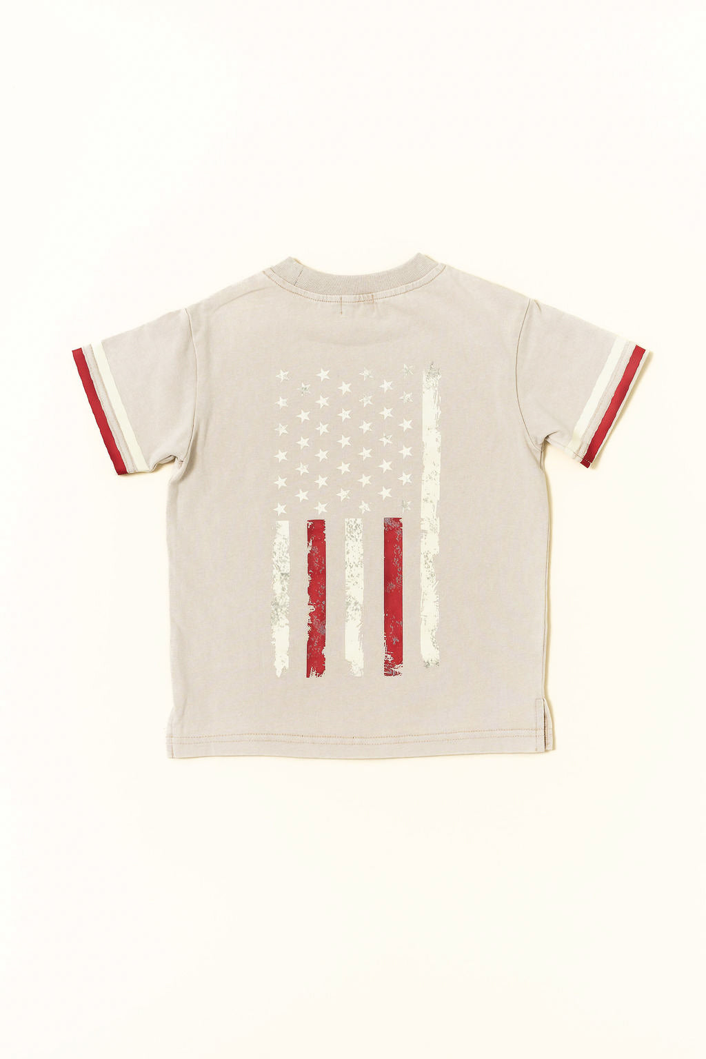 Beige t-shirt with American flag design on a white background by rad toddler