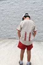 Kid wearing the American Original Tee in a vintage beige color with classic Americana-inspired graphic design.