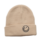 A beige knitted beanie with a embroidered smiley face on the cuff.