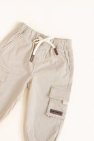 Beige cargo pants with a drawstring on a white background