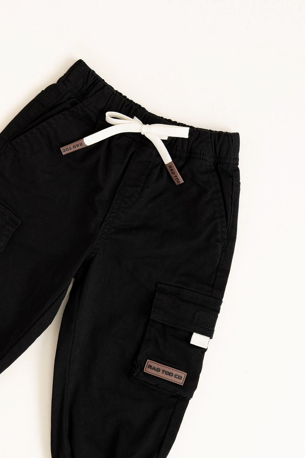 Black cargo pants with white drawstring on a white background