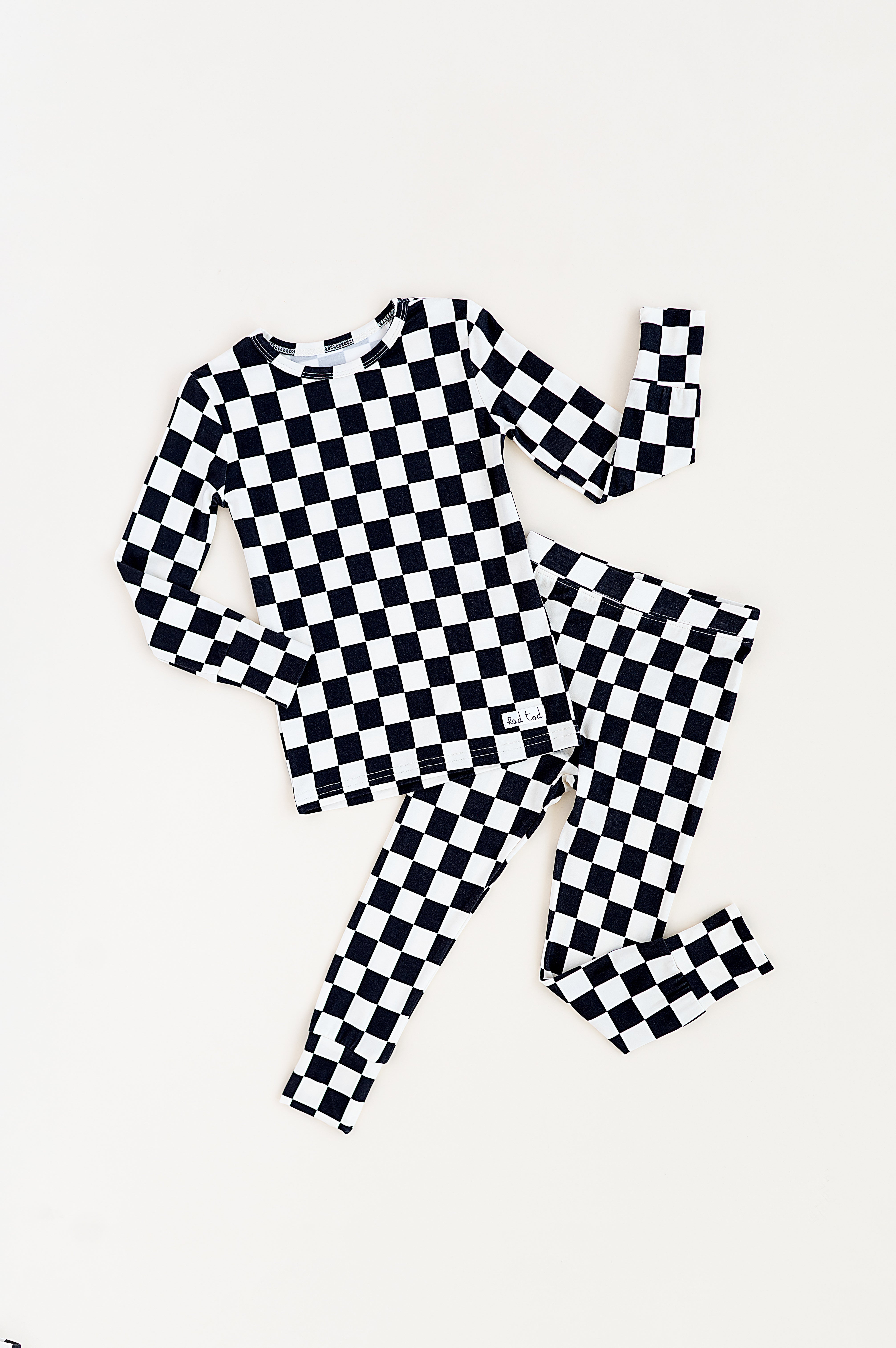 Black checkered 2-piece pajamas for toddlers and kids, featuring a comfy fit and elastic waistband by Rad Toddler.