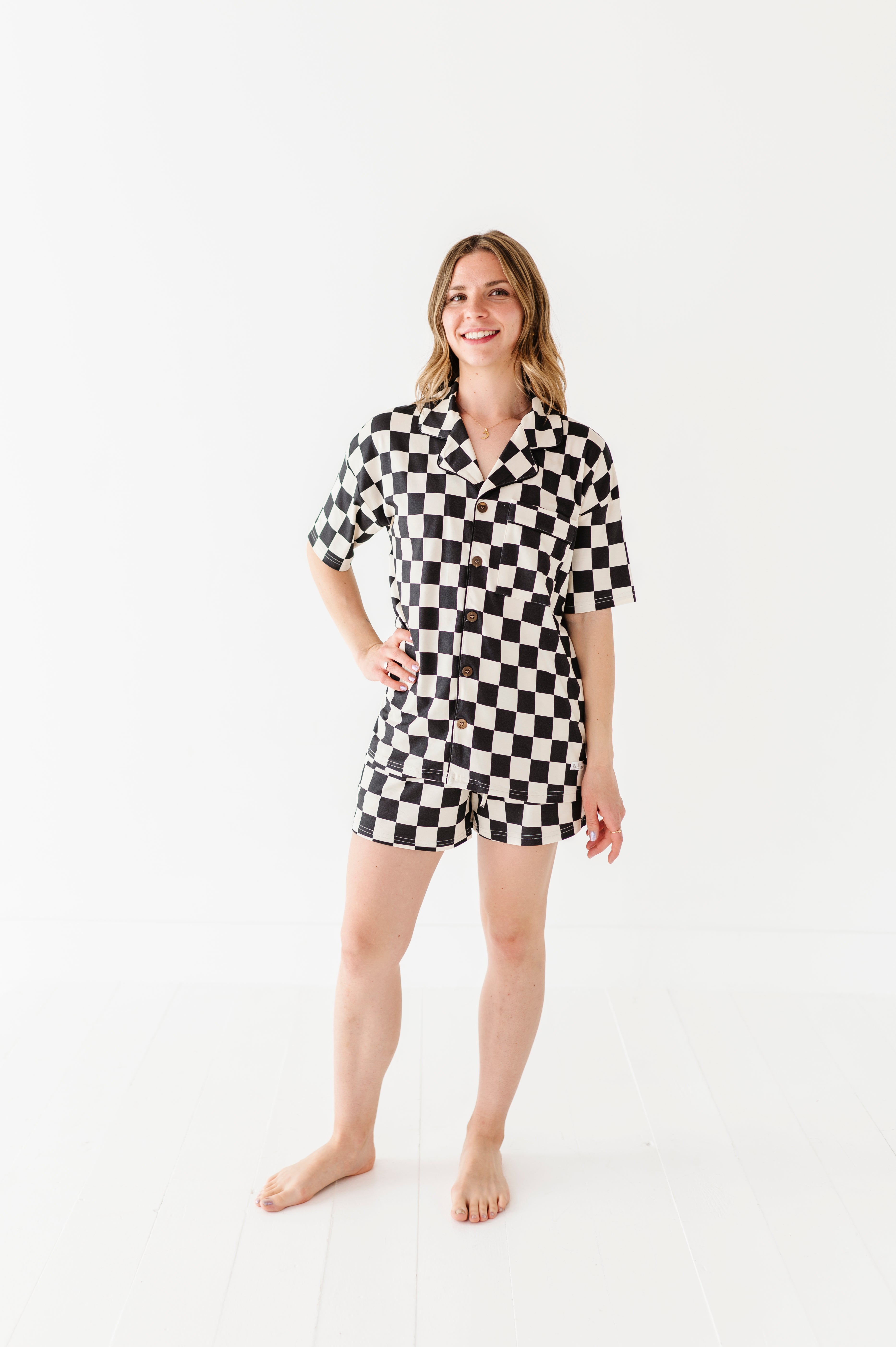 woman wearing Black and white checkered bamboo short sleeve pajama set for women, featuring soft, breathable fabric and a relaxed fit by Rad Toddler.