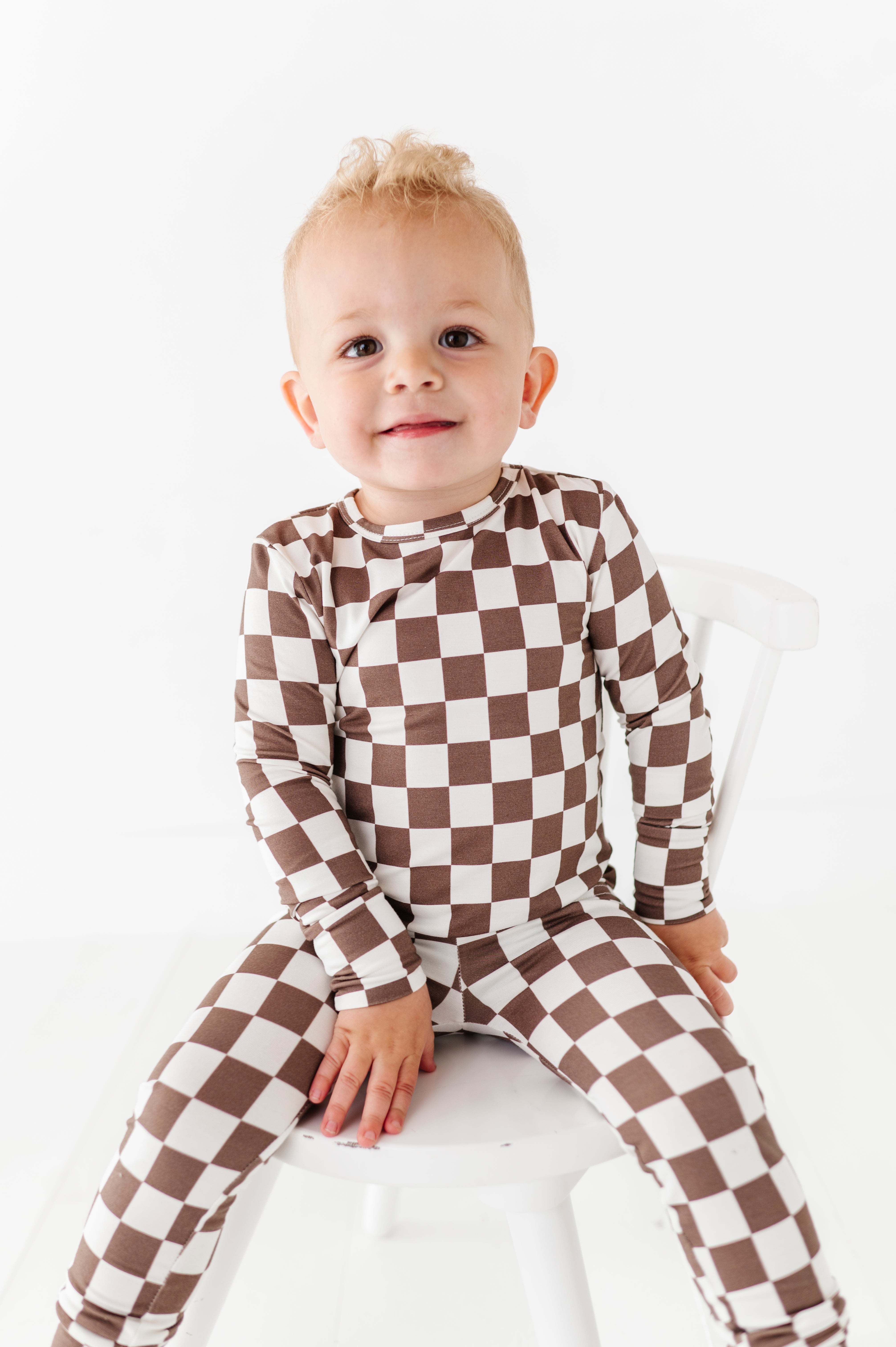 boy wearing Bronze and white checkered bamboo 2-piece pajama set for toddlers, featuring a short sleeve top and elastic waistband pants by Rad Toddler.