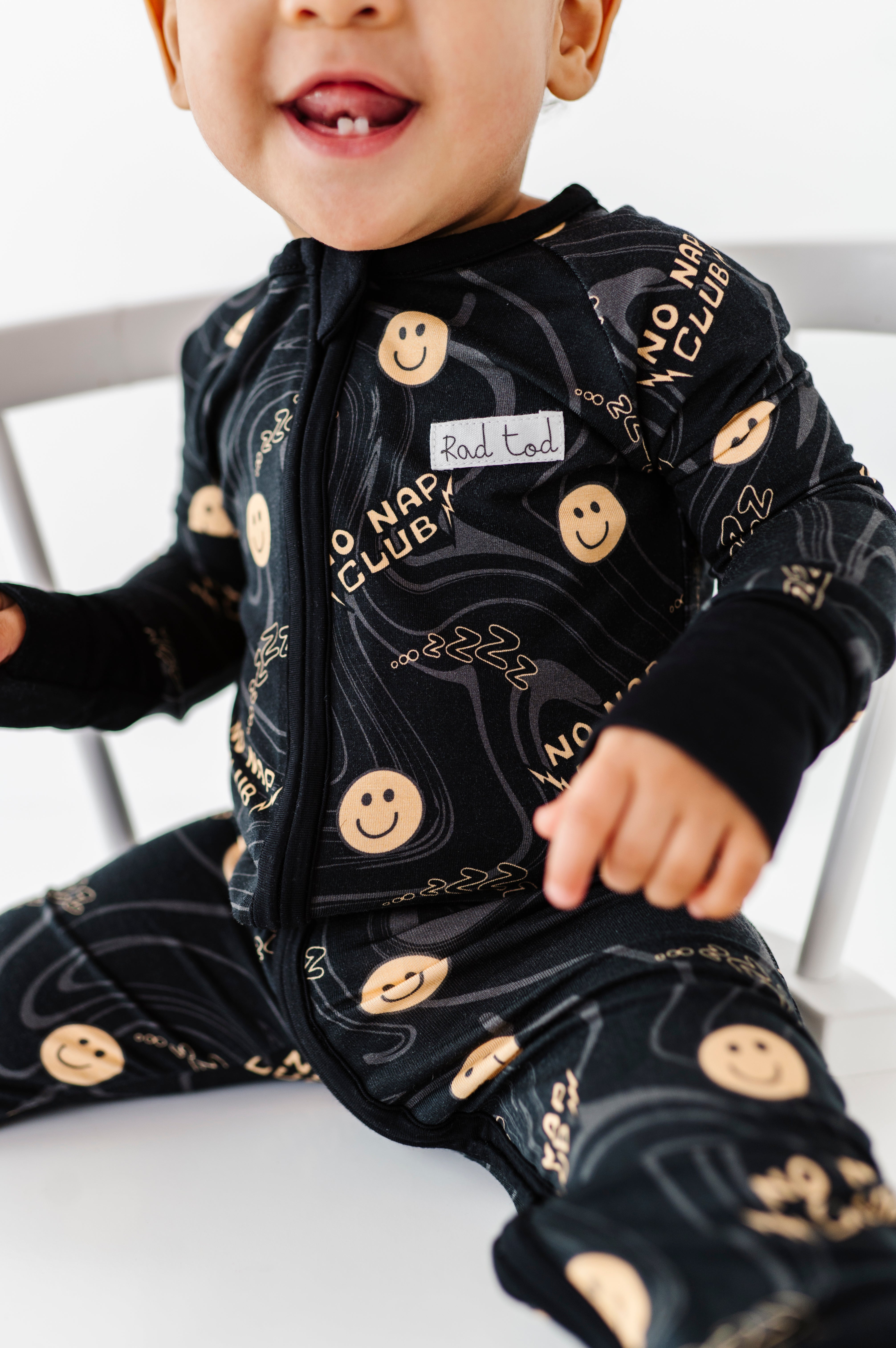 Black bamboo onesie with smiley face graphics and wavy lines for active toddlers