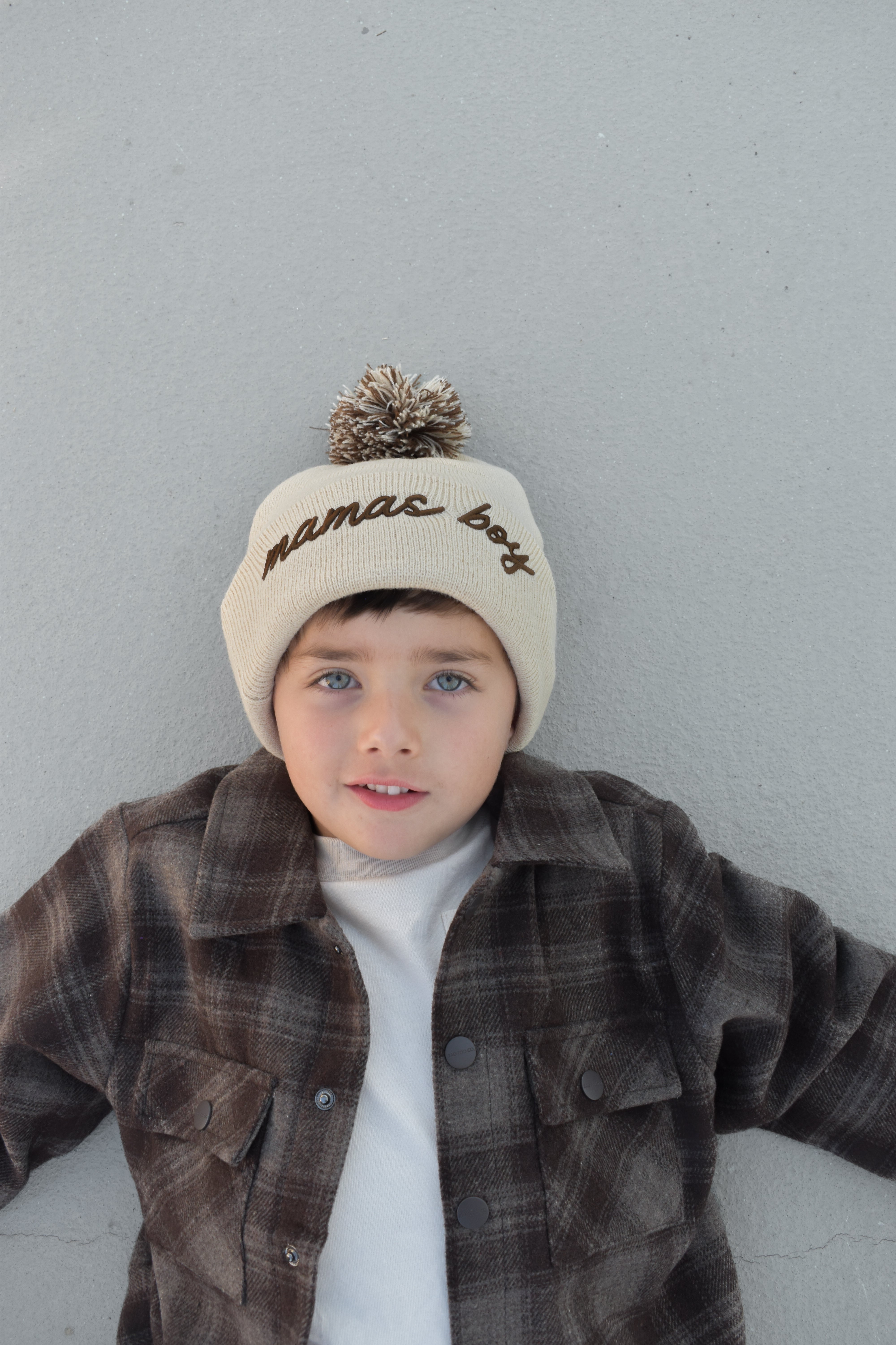 Toddler wearing beige Mamas Boy beanie with brown lettering