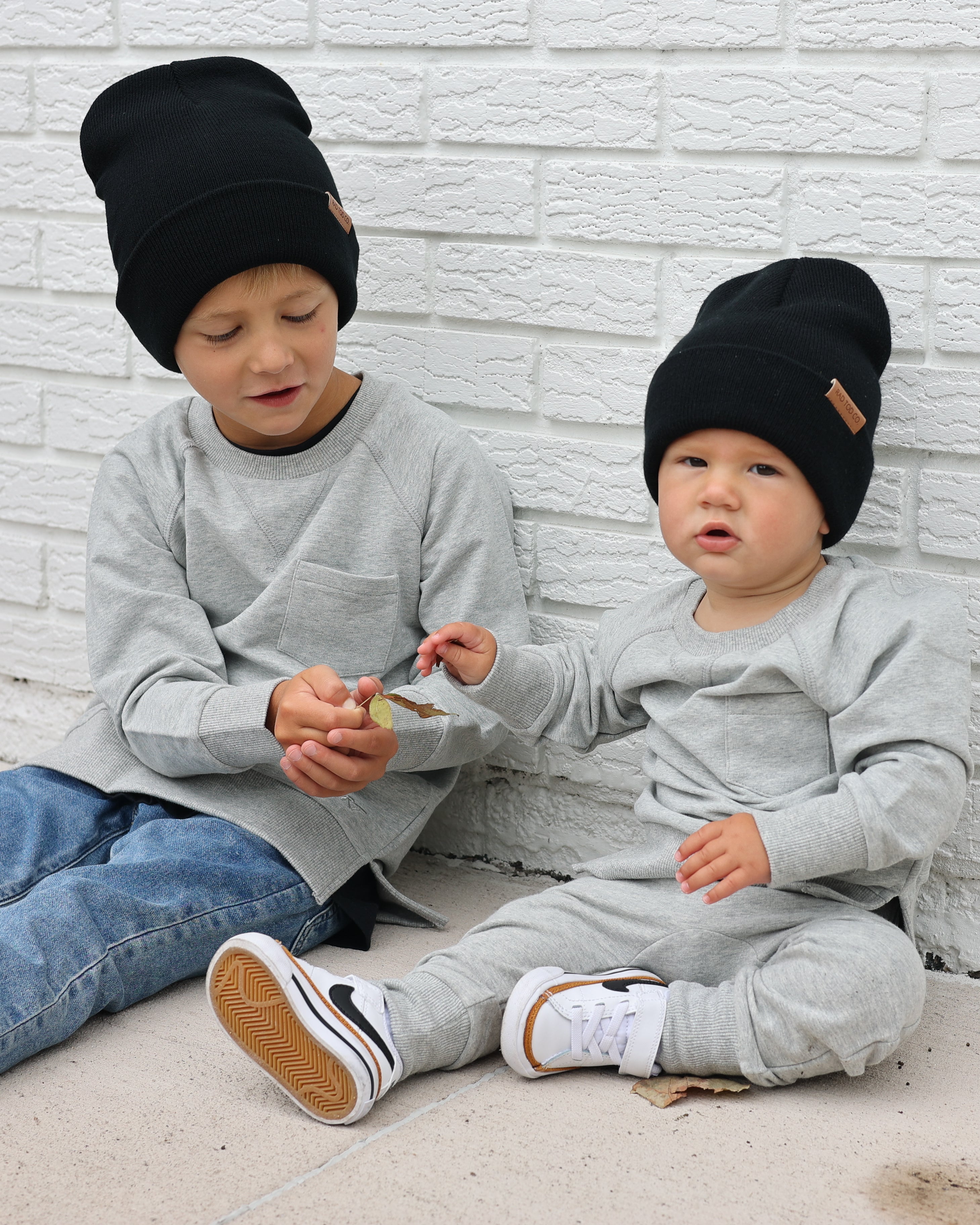 brothers wearing gray Core Collection toddler crewneck with oversized fit, standing outdoors.