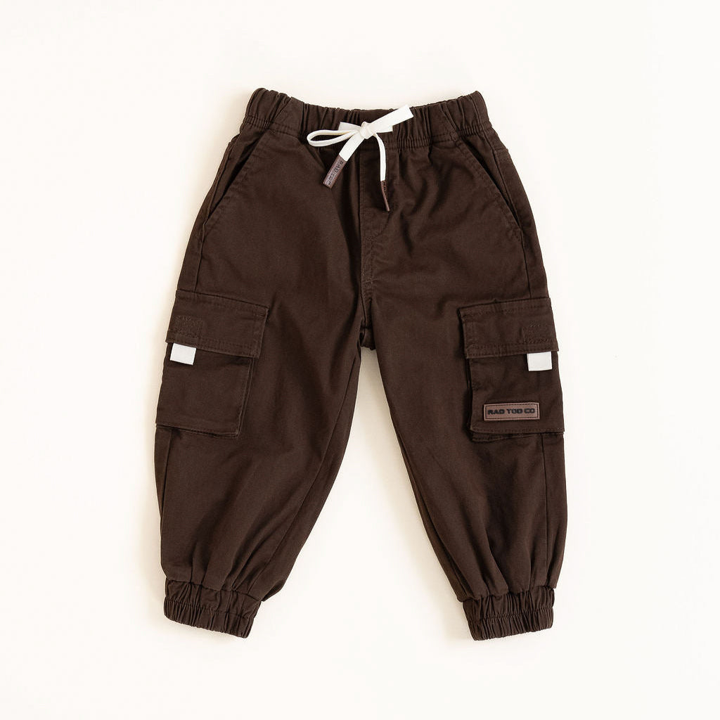 Brown cargo pants with white drawstring on a beige background