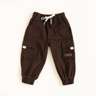 Brown cargo pants with white drawstring on a beige background