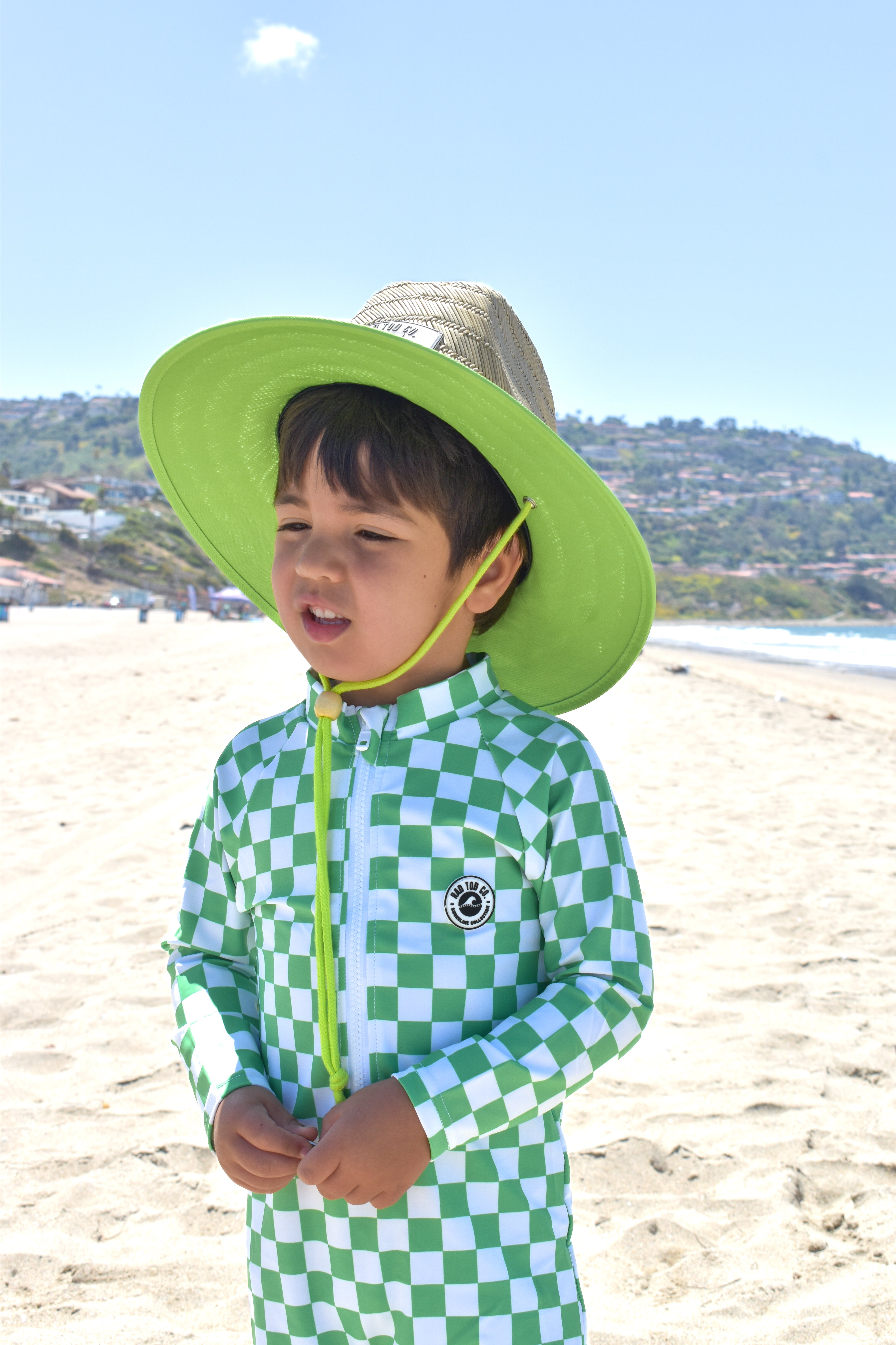 Stylish kids rashguard onesie green checker surf style and straw hat by rad toddler