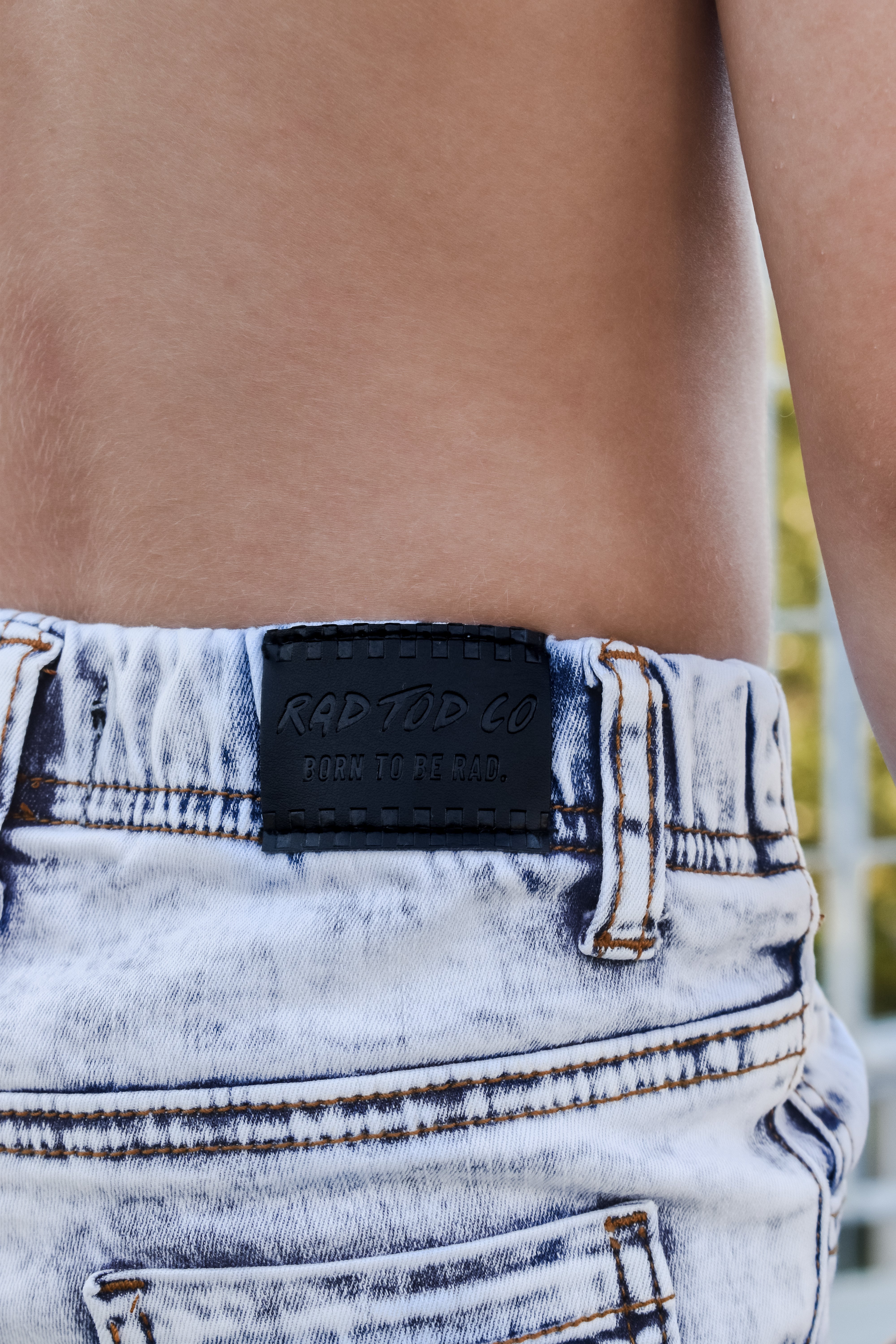 Close-up of a denim product with a brand label on a blurred background