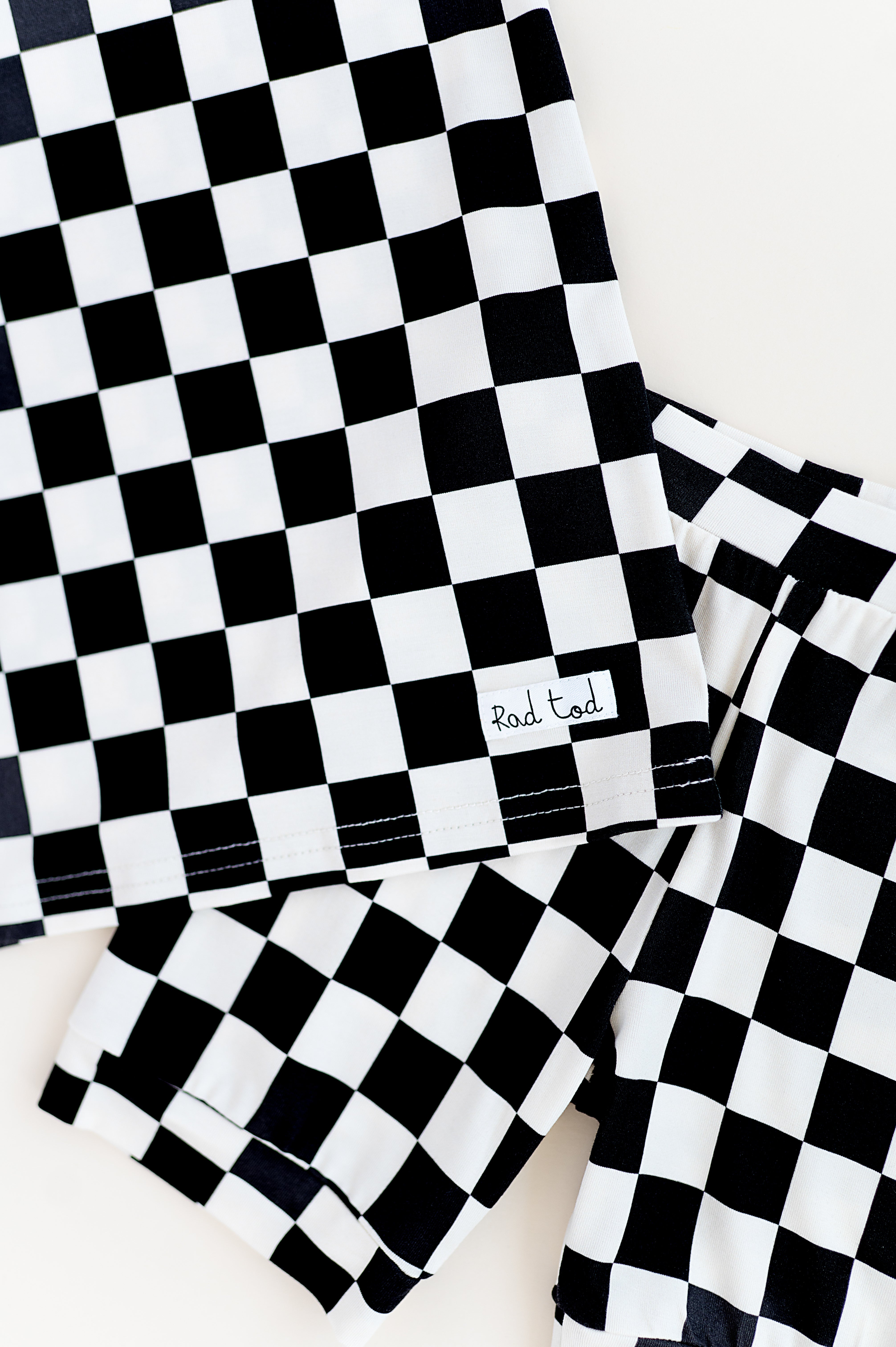 details on Black and white checkered bamboo short sleeve pajama set for toddlers, featuring a soft, breathable fabric and stretchy waistband by Rad Toddler.