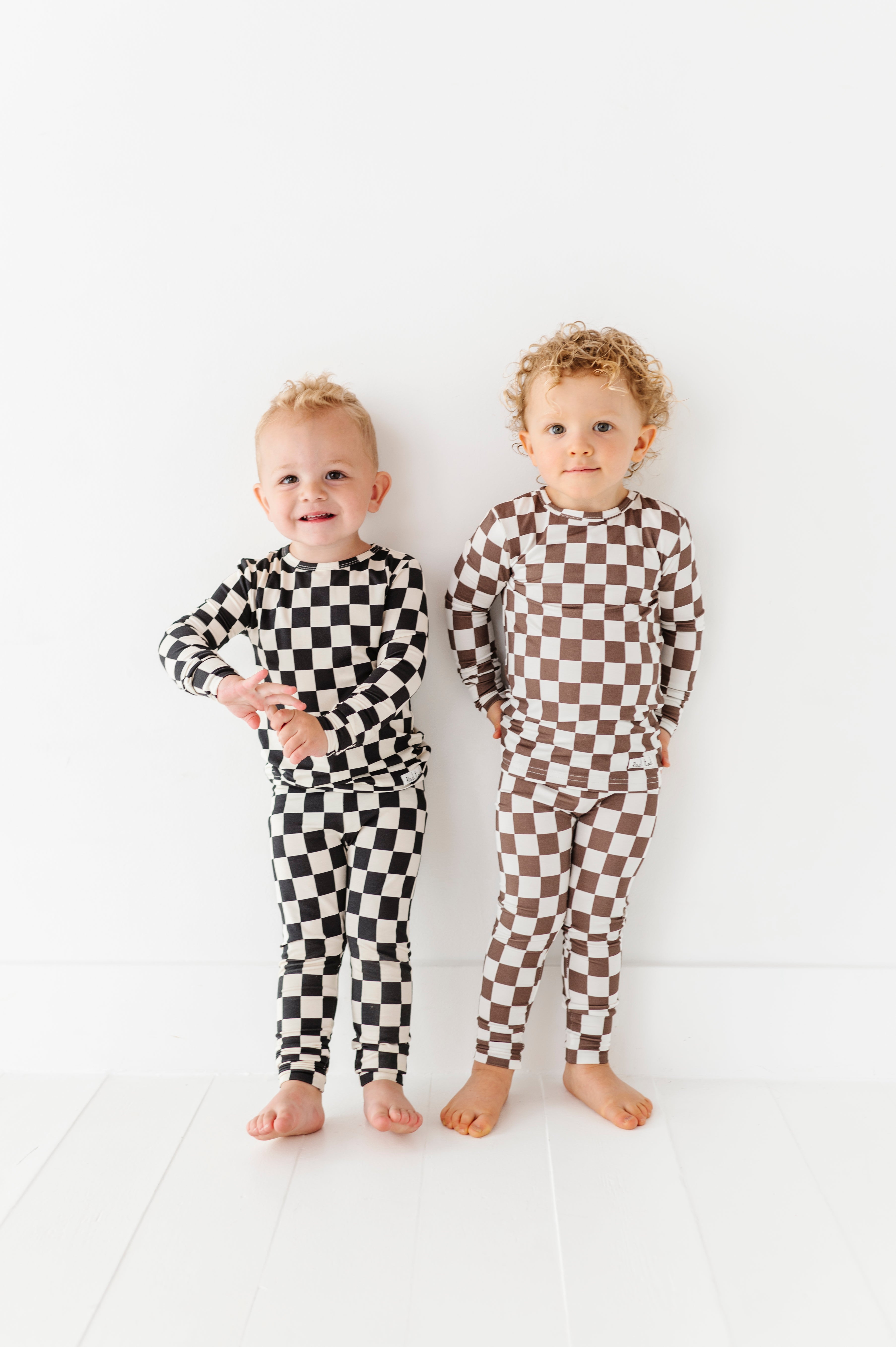 2 boys wearing Bronze and white checkered bamboo 2-piece pajama set for toddlers, featuring a short sleeve top and elastic waistband pants by Rad Toddler.