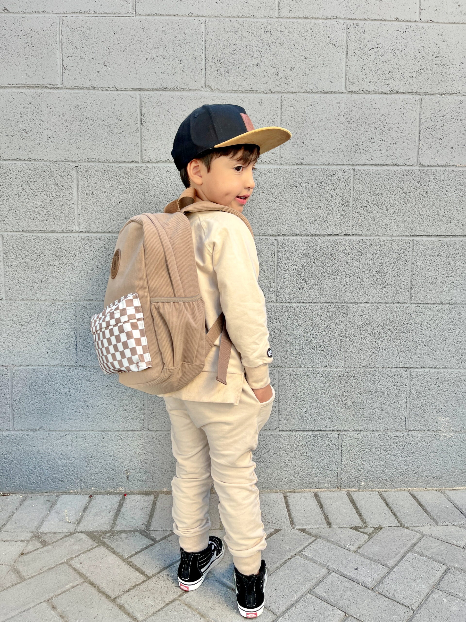 toddler wearing dune toddler backpack with checker accent and vegan leather