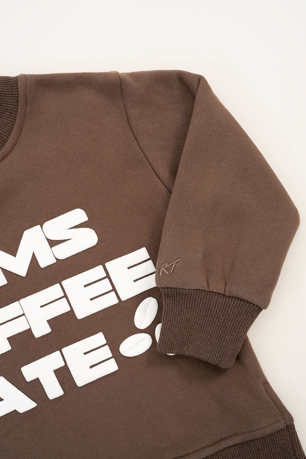 Coffee-brown crewneck with bold off-white “Mom’s Coffee Date” lettering, laid flat on a neutral background.