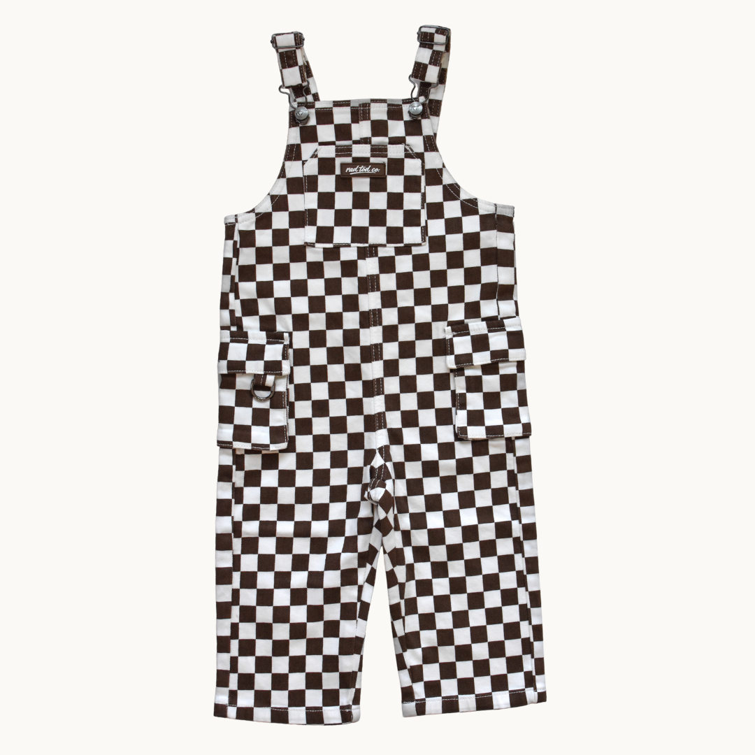 Rad Tod Overalls in brown and white checkerboard pattern, featuring adjustable shoulder straps and front utility pockets, shown flat against a light off-white background.