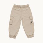 A pair of beige cargo pants with elastic waist and ankle cuffs, featuring side cargo pockets and a small black lightning bolt logo on one pocket, shown against a plain off-white background.
