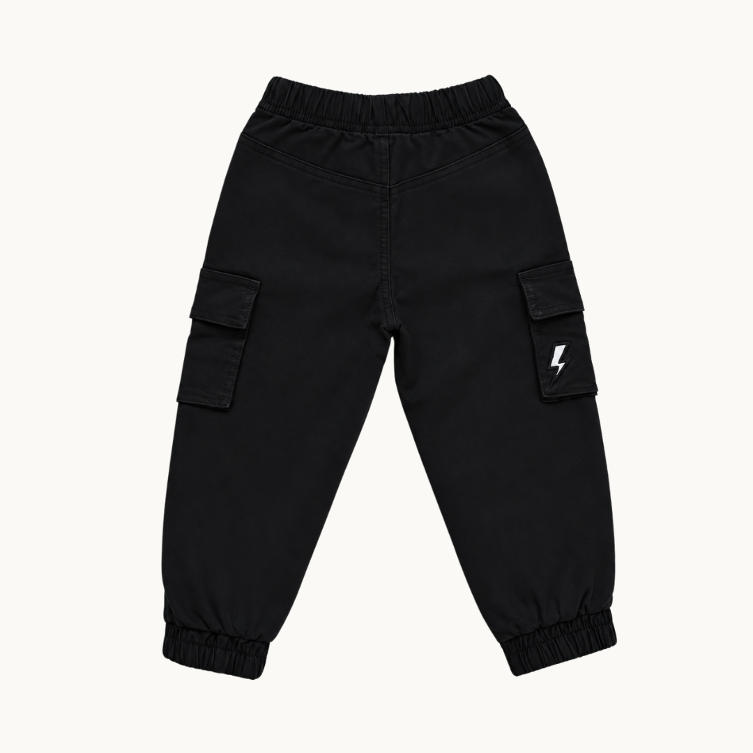 Black cargo jogger pants with elastic waistband and cuffs, featuring side cargo pockets and a small white lightning bolt logo on one pocket, shown flat on a light off-white background.