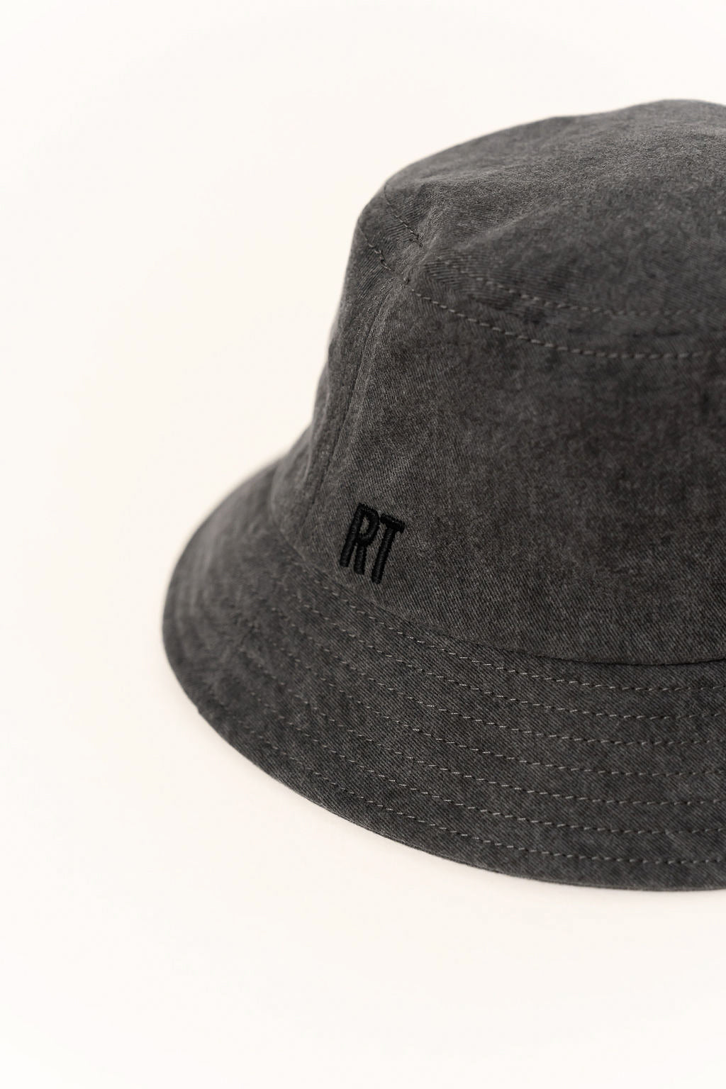 Dark gray bucket hat with a small logo on a white background